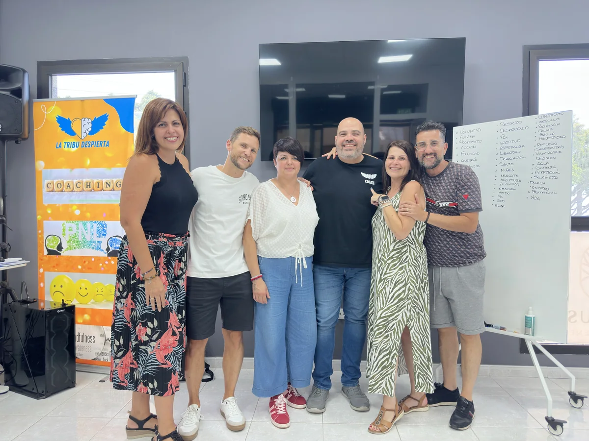 Grupo de alumnos junto al roll-up de coaching y PNL de La Tribu Despierta, al cerrar una formacion en el Centro Aurus