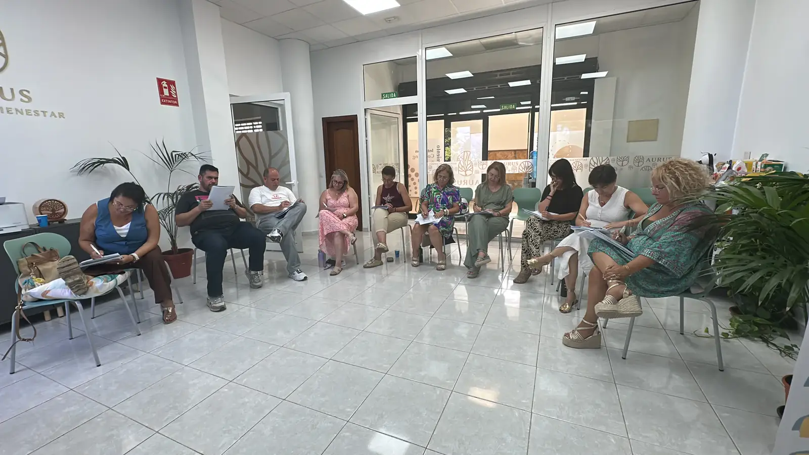 Círculo de participantes sentados durante una sesión en el Centro Aurus