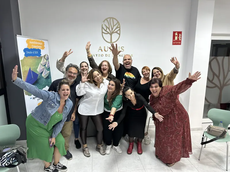 Grupo con los brazos en alto al terminar un taller en el Centro Aurus