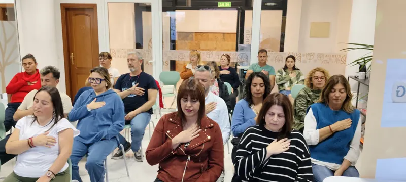 Personas con la mano en el pecho en una dinámica de grupo